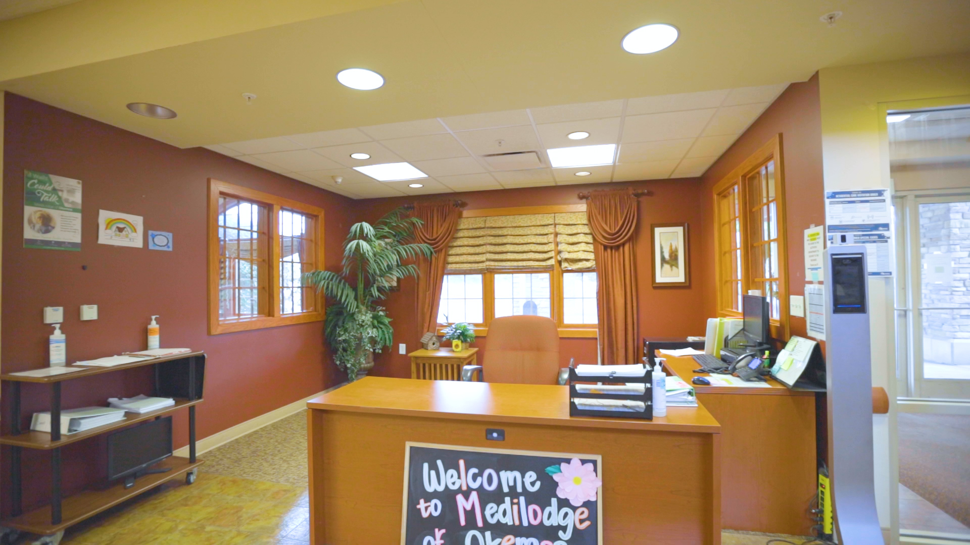 Front desk with Welcome sign. Three windows on the background.